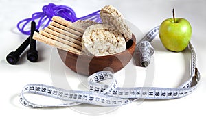 Different fitness equipment with apple and cereal crispbread