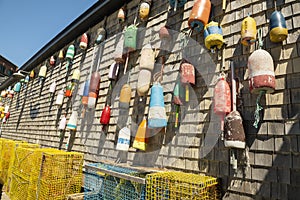 Different floats and buoys on the wall of a wooden house. USA. Maine.