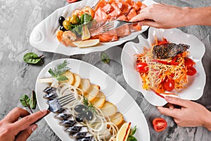 Different food with Seafood platter with smoked mackerel slice, fried potatoes, salmon slice, shrimp and vegetable salad on table