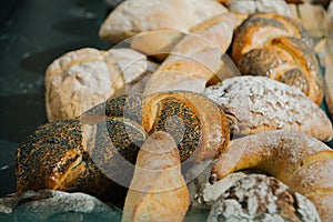 Different fresh bread on the shelves in bakery. Selective focus