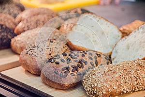 Different fresh bread on the shelves in bakery. Selective focus