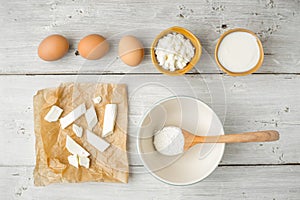 Different fresh cheese with yogurt and eggs on the white wooden table top view