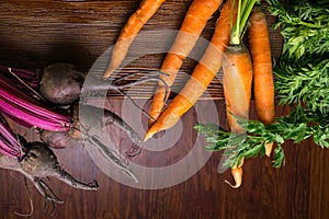 different fresh farm vegetables, organic beetroots and carrots on rustic wooden background, selective focus