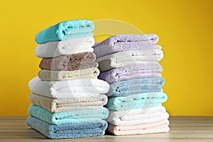 Different fresh soft terry towels on wooden table
