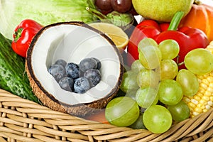 Different fresh vegetables and fruits in wicker basket, closeup