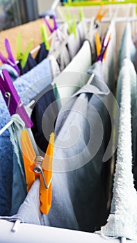 Different freshly clothes hanging with pins on the clotheshorse for drying on the balcony photo