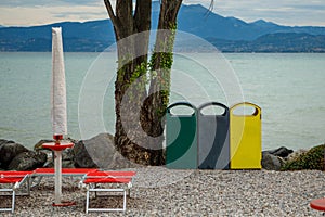 3 different garbage cans to separate garbage stand on the shore of Garda Lake photo