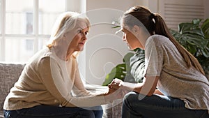 Different generations women talking holding hands giving psychological support