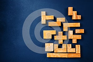Different geometric shapes wooden blocks on a dark background. Creative, logical thinking and problem solving concept. Copy space