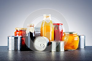 Different glass jars with grains, pasta, vegetable, cans of canned food