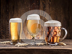 Different glasses of beer on the wooden table.