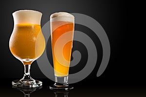 Different glasses and cups with beer, on a dark table, dark background and copy space