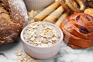 Different gluten free products on white marble table, closeup