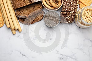 Different gluten free products on white marble table, flat lay. Space for text