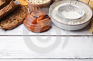 Different gluten free products on white wooden table, space for text