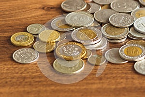 Different gold and silver collector coins on the wooden background