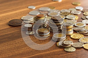Different gold and silver collector`s coins on the wooden table