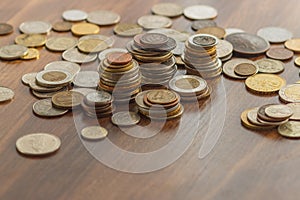 Different gold and silver collector`s coins on the wooden table