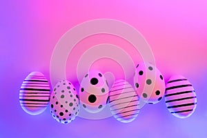 Different graphic hand-painted eggs in Proton Purple neon light.