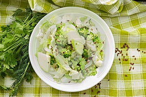 Different green and white, fresh, raw vegetables in the white bowl with flax seeds