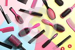 Different hair brushes, combs and scrunchies on color background, flat lay