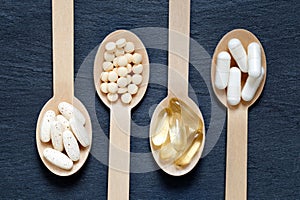 Different healthy supplements on wooden spoons