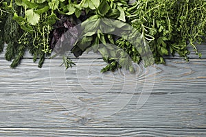 Different herbs on gray wooden background, top view