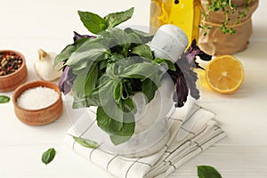 Different herbs, oil and spices on white wooden table