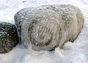 different ice formations on rocks on the seashore, ice texture, wind, water and ice working together