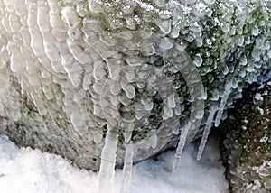 different ice formations on rocks on the seashore, ice texture, wind, water and ice working together