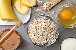 Different ingredients for handmade face mask on grey table