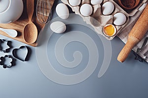 Different ingredients and kitchen utensils for making cookies or cupcakes, flat lay, copyspace. Eggs, rolling pin, whisk, flour,