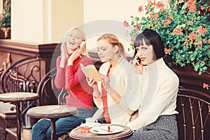 Different interests. Hobby and leisure. Group pretty women cafe terrace entertain themselves with reading speaking and