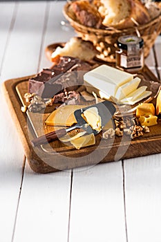 The different kind of cheese and walnuts on wooden background