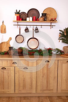 Different kind of cookware and tools on tabletop. Kitchen Railing on wall with coppers skillets and cups. Interior rustic cuisine. photo