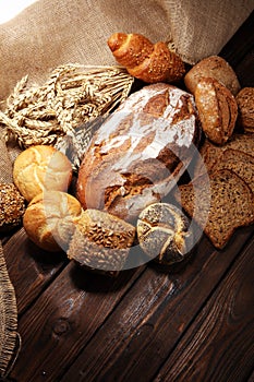 Different kinds of bread and bread rolls on board from above