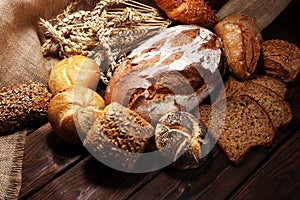 Different kinds of bread and bread rolls on board from above