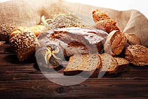 Different kinds of bread and bread rolls on board from above