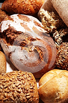 Different kinds of bread and bread rolls on board from above