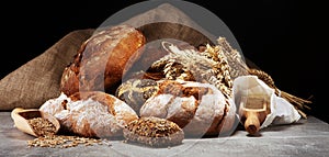 Different kinds of bread and bread rolls on board from above. Kitchen or bakery