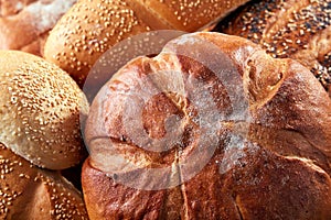 Different kinds of bread and bread rolls on board from above. Kitchen or bakery poster design. Close-up.