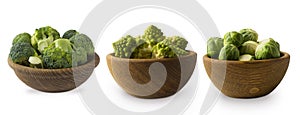 Different kinds of cabbage in a wooden bowl. Broccoli, Brussels sprouts, Roman cauliflower isolated on white background.