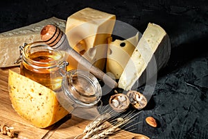 Different kinds of cheese with nuts and honey