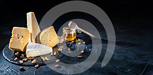 Different kinds of cheese with nuts and honey
