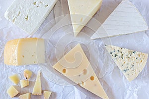 Different kinds of cheeses on paper