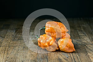 Different kinds of hot chili peppers on table on black backgrou