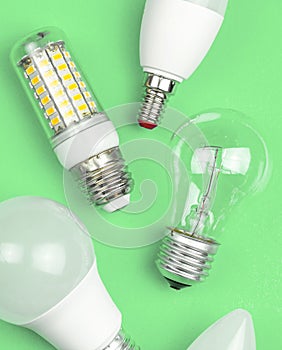 Different kinds of light bulbs together, eco green background. Energy saving concept. Flat lay, top view photo