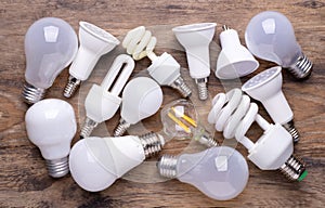 Different kinds of light bulbs on wooden background photo