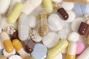 Different kinds pills falling on white background in slow motion. Multi-colored tablets are flying. Beautiful drop pills