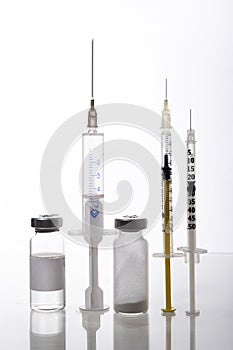 Different kinds of syringe,glass bottles of medicaments on the glass surface